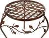 A close-up view of a decorative metal plant stand with a lattice top and a bird and leaf motif on the legs. Produktbild-Vorschau