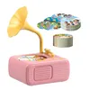 A pink toy gramophone with a yellow horn, accompanied by stacks of round cards. Produktbild-Vorschau