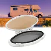 A white oval porthole with a mesh screen and a tan interior is shown in the foreground, with a recreational vehicle (RV) parked on a road in the background. Anteprima dell’immagine prodotto