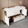 A modern sideboard with white high-gloss fronts and wood-grain accents, featuring open drawers and doors revealing storage compartments. A vase with decorative branches sits on top. Voir les images du produit
