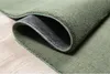 A close-up view of a green rug, showing the texture and the anti-slip backing. Produktbild-Vorschau