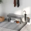 A hallway scene with a bench, shoes, an umbrella, and a basket. Produktbild-Vorschau