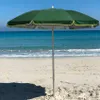 A green beach umbrella on a sandy beach with the ocean in the background. Anteprima dell’immagine prodotto