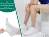 A person wearing white socks and white sneakers is sitting on white steps, with a close-up of a white sock being stretched to show its elasticity. Produktbild-Vorschau