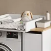 A baby changing station with a washing machine underneath. Produktbild-Vorschau