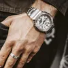 A close-up shot of a person's wrist wearing a silver G-Shock watch and a ring. Voir les images du produit