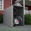 A portable storage tent for a bicycle and a scooter is set up in front of a house. Produktbild-Vorschau