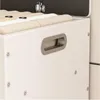 A close-up view of a white storage unit with a silver handle and beige fabric inside. Produktbild-Vorschau