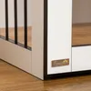 A close-up view of the corner of a white and black dog crate, showing a small metallic logo with paw prints and text. Podgląd zdjęcia produktu