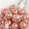 Stapel von Rosenquarz- und klaren Konfetti-Luftballons, mit einer Rolle rotem Klebeband und einem Bogen Klebepunkten im Vordergrund Náhled obrázku produktu