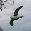A plastic bird decoy is hanging from a string against a cloudy sky. Náhled obrázku produktu