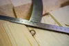 A close-up of a metal measuring tool on a wooden surface. Anteprima dell’immagine prodotto