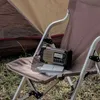 A portable radio sits on a folding chair next to a tent, suggesting an outdoor or camping setting. Anteprima dell’immagine prodotto