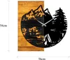 A wall clock with a mountain and forest scene design. Voir les images du produit