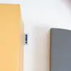 A close-up of a label on a yellow object and a gray object next to it. Anteprima dell’immagine prodotto