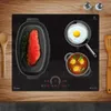 A close-up shot of a black induction cooktop with food being prepared on it. Produktbild-Vorschau