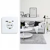 A split image showing a white electrical socket with USB ports on the left and a modern living room scene on the right. Produktbild-Vorschau