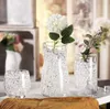 Three glass vases filled with water beads and flowers, arranged on a table. Produktbild-Vorschau