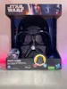 A Star Wars Darth Vader voice-changing mask in its retail packaging, displayed on a reflective surface with pink lighting on the sides. Anteprima dell’immagine prodotto