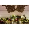 A Christmas garland with LED lights, holly leaves, berries, and pinecones is displayed on a wooden surface, with a decorative jute garland above. Produktbild-Vorschau