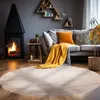 A cozy living room scene with a fireplace, sofa, and a round rug. Anteprima dell’immagine prodotto
