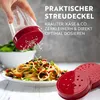 A hand is shown holding a clear and red grater, sprinkling grated cheese onto a plate of spaghetti. Produktbild-Vorschau