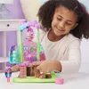 A young girl is playing with a toy treehouse playset. Náhled obrázku produktu