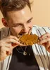 A man is eating a slice of bread with spread. Produktbild-Vorschau