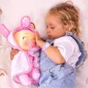 A young girl is lying in bed with a baby doll. Náhľad obrázku produktu