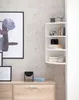 A corner shelf unit with decorative items and books is mounted on a textured wall above a wooden cabinet. Anteprima dell’immagine prodotto