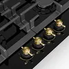 A close-up view of a black gas stovetop with gold control knobs. Náhľad obrázku produktu