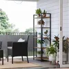 An outdoor patio scene with furniture and plants on a shelf. Produktbild-Vorschau