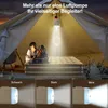 A family is relaxing on an air mattress inside a tent, illuminated by a hanging light. Produktbild-Vorschau