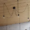 A modern pendant light fixture with multiple bulbs hanging from a wooden ceiling. Anteprima dell’immagine prodotto