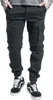 A person wearing black cargo pants and black sneakers. Produktbild-Vorschau