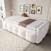 A bedroom or living room setting with a daybed, laundry machines, and framed pictures on the wall. Produktbild-Vorschau
