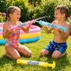 Drei 'Fireworks Water Gun'-Spielzeuge in Pink, Blau und Gelb, die von zwei Kindern in einem Hinterhof benutzt werden Produktbild-Vorschau