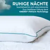 A close-up of a white pillow with a teal trim, set against a teal background with clouds and stars. Produktbild-Vorschau