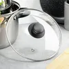 A close-up shot of a glass pot lid with a black handle, resting on a countertop. Produktbild-Vorschau