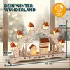 A wooden Christmas arch with LED lights, depicting a winter village scene, set against a blurred winter window background. Náhled obrázku produktu