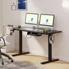 A black standing desk with two monitors, a chair, and office supplies. Voir les images du produit