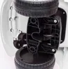 A close-up view of the underside of a white ride-on toy car, showing the wheels and chassis. Náhled obrázku produktu