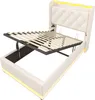 A white upholstered bed frame with its mattress support mechanism lifted, revealing storage space underneath. Yellow LED lighting is visible along the headboard and base. Náhled obrázku produktu