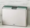 A set of cutting boards in a silver holder, placed on a white countertop against a marble-patterned wall. Anteprima dell’immagine prodotto