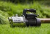 A water pump sits on a grassy lawn. Produktbild-Vorschau