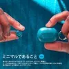 Hands holding small teal earbuds and a charging case against a blue background. Anteprima dell’immagine prodotto