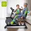 An older woman is exercising on a recumbent exercise bike, with a young boy standing next to her, cheering her on. Green overlays highlight the woman's joints and spine, with checkmark icons indicating protection or benefit. Produktbild-Vorschau
