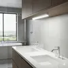 A modern bathroom with a double vanity, bathtub, and a large window with a view. Produktbild-Vorschau