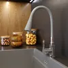 A kitchen sink area with a faucet and storage jars. Podgląd zdjęcia produktu