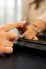 A close-up shot of a hand touching a mirror with a power button symbol. Náhled obrázku produktu